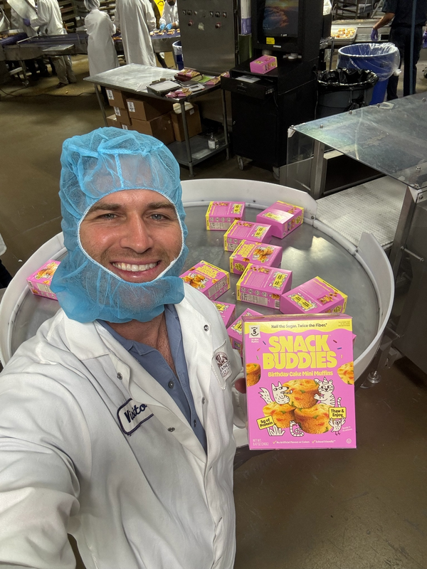 Drew holding Snack Buddies on the production floor