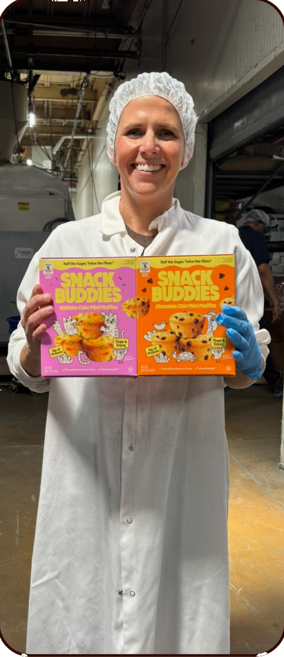 Amanda holding Snack Buddies on the production floor